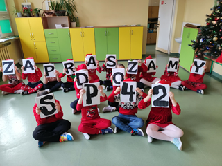 Uczniowie trzymają napis Zapraszamy do SP 42